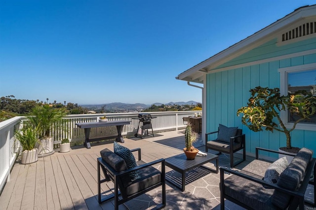 wooden deck with a mountain view and outdoor lounge area