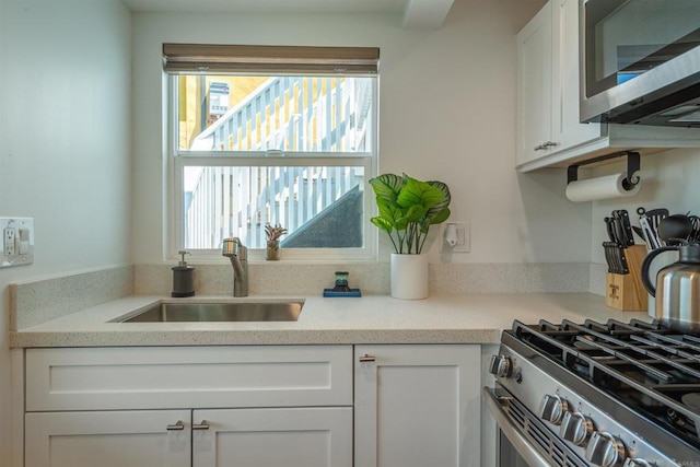 kitchen with sink, white cabinets, and appliances with stainless steel finishes