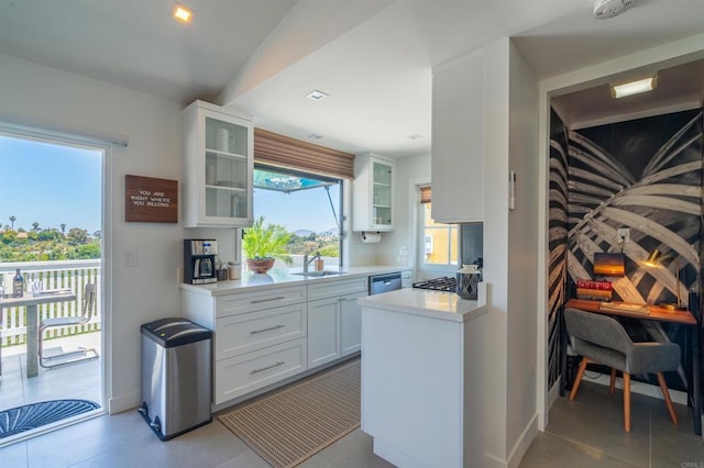 kitchen with sink, white cabinets, light tile patterned floors, and appliances with stainless steel finishes