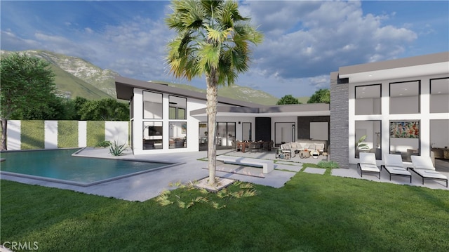 rear view of house featuring a mountain view, a yard, a fenced in pool, and a patio area