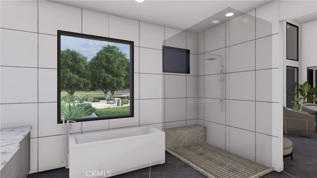 bathroom with plenty of natural light, tile walls, and tile patterned flooring