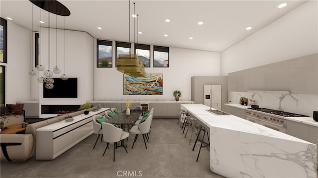 kitchen with white refrigerator with ice dispenser, decorative light fixtures, decorative backsplash, a large island, and light stone counters