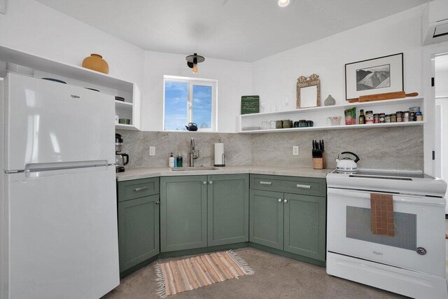 kitchen with stove, tasteful backsplash, sink, green cabinetry, and white fridge