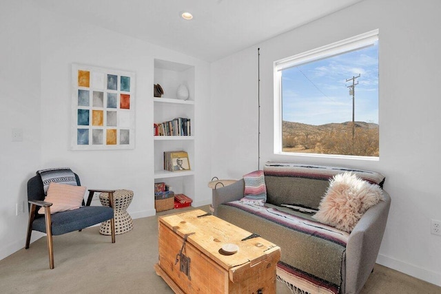 sitting room featuring a mountain view, light colored carpet, and built in features