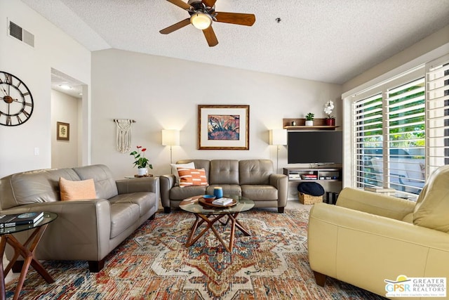 living room with a textured ceiling, ceiling fan, and lofted ceiling