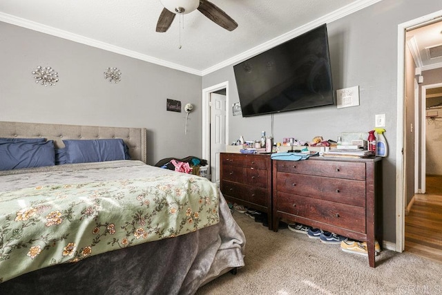 bedroom featuring light carpet, ornamental molding, and ceiling fan