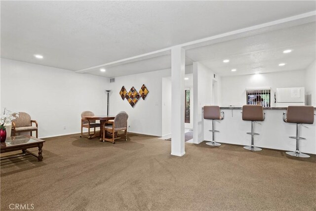 sitting room with bar and carpet flooring