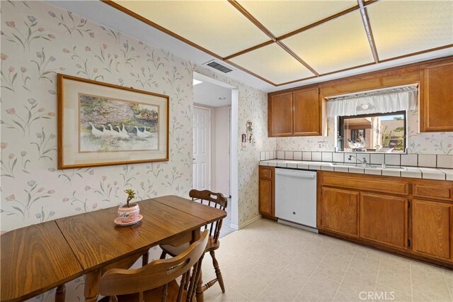 kitchen with dishwasher, sink, and tile countertops