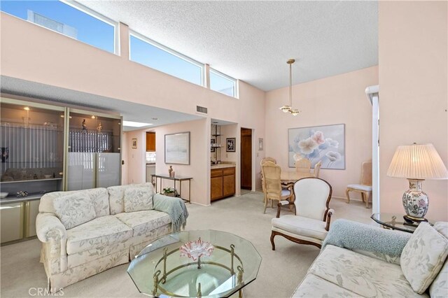 carpeted living room with a towering ceiling and a textured ceiling