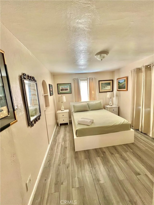 unfurnished bedroom featuring light hardwood / wood-style floors and a textured ceiling