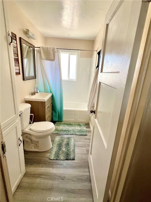 full bathroom with vanity, toilet, shower / bathtub combination with curtain, and hardwood / wood-style flooring