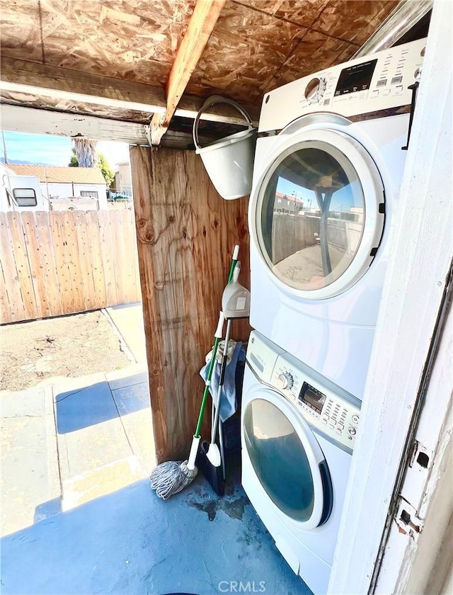 clothes washing area featuring stacked washer and clothes dryer