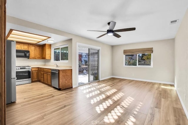 kitchen featuring ceiling fan, a healthy amount of sunlight, light hardwood / wood-style floors, and stainless steel appliances