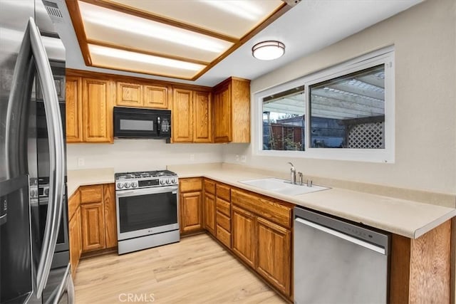 kitchen with sink, light wood-type flooring, and stainless steel appliances