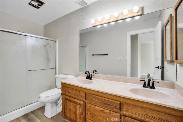 bathroom featuring hardwood / wood-style flooring, vanity, toilet, and walk in shower