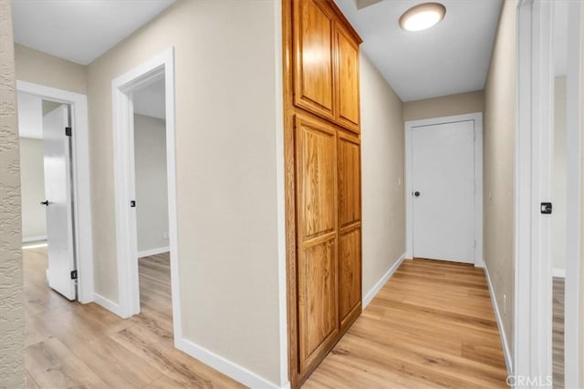 hallway with light hardwood / wood-style floors