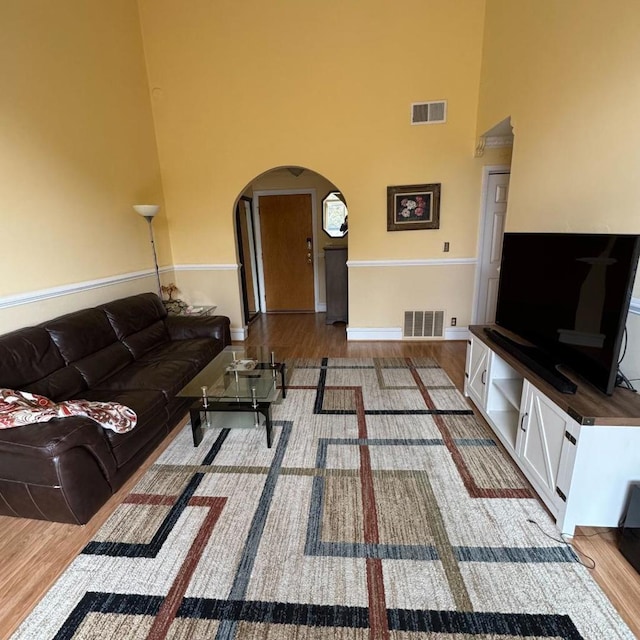 living room featuring hardwood / wood-style flooring and a high ceiling