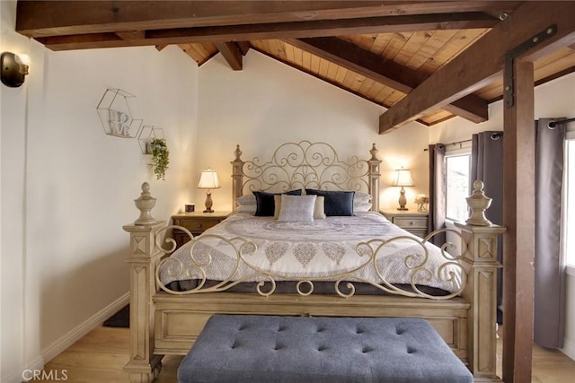 bedroom featuring vaulted ceiling with beams and light hardwood / wood-style floors