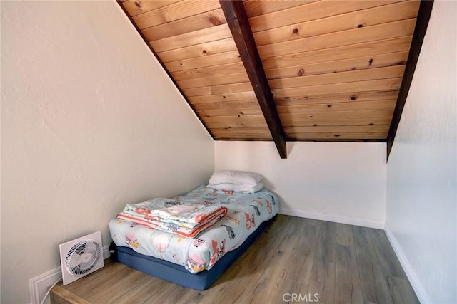 unfurnished bedroom with lofted ceiling with beams, dark hardwood / wood-style floors, and wooden ceiling