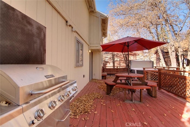 wooden deck featuring a grill