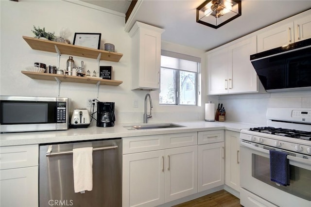 kitchen featuring white cabinets, appliances with stainless steel finishes, wood-type flooring, and sink