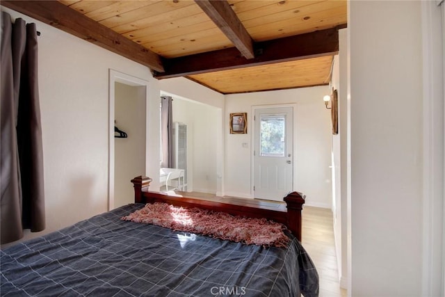 unfurnished bedroom featuring beam ceiling, wood-type flooring, and wooden ceiling