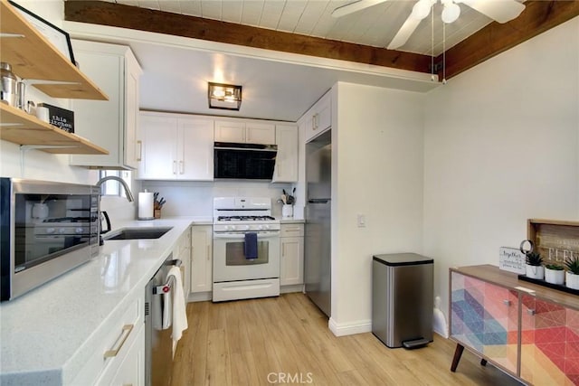 kitchen featuring appliances with stainless steel finishes, sink, beam ceiling, light hardwood / wood-style floors, and white cabinetry