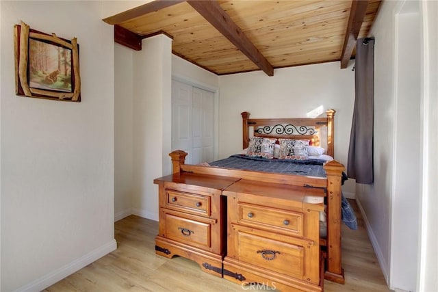 bedroom with beamed ceiling, light hardwood / wood-style floors, wood ceiling, and a closet