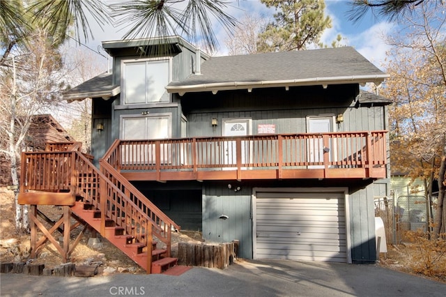 rear view of house with a garage and a deck