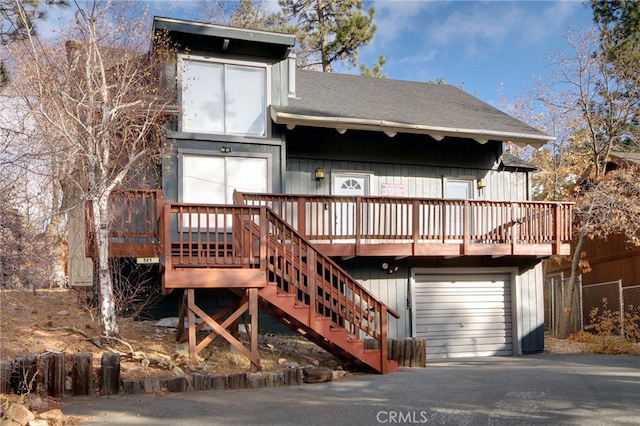 rear view of house featuring a garage and a deck