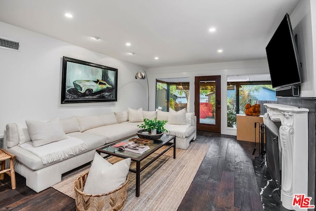 living room featuring hardwood / wood-style flooring, a wealth of natural light, and a fireplace