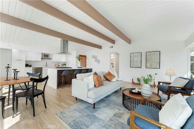 living room featuring lofted ceiling with beams and light wood-type flooring