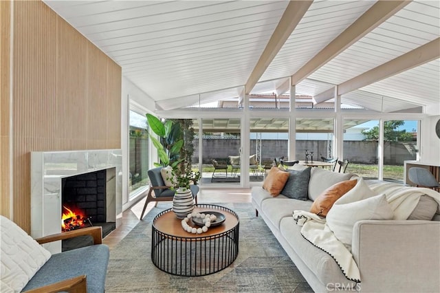 sunroom / solarium featuring vaulted ceiling with beams and a high end fireplace