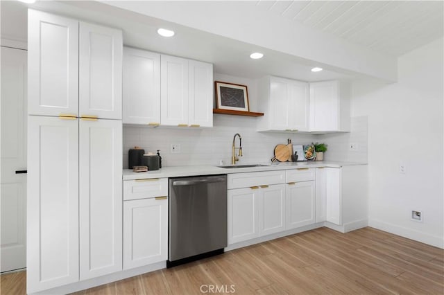 kitchen with stainless steel dishwasher, white cabinetry, and sink