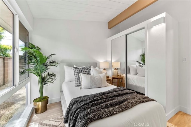 bedroom with wooden ceiling, a closet, lofted ceiling with beams, and light wood-type flooring