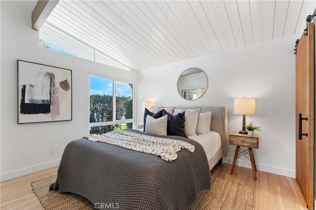 bedroom with vaulted ceiling with beams, light hardwood / wood-style floors, and wood ceiling