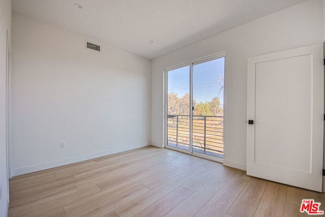 empty room with light hardwood / wood-style flooring