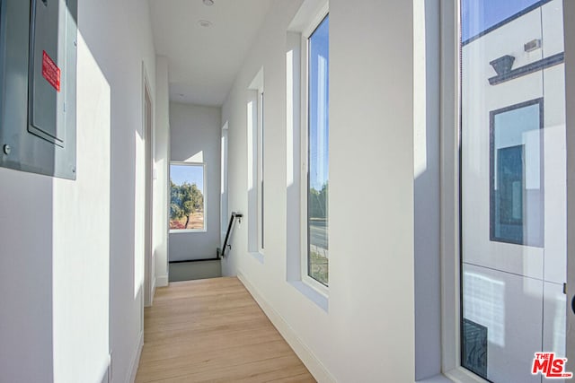 hallway with electric panel and light wood-type flooring