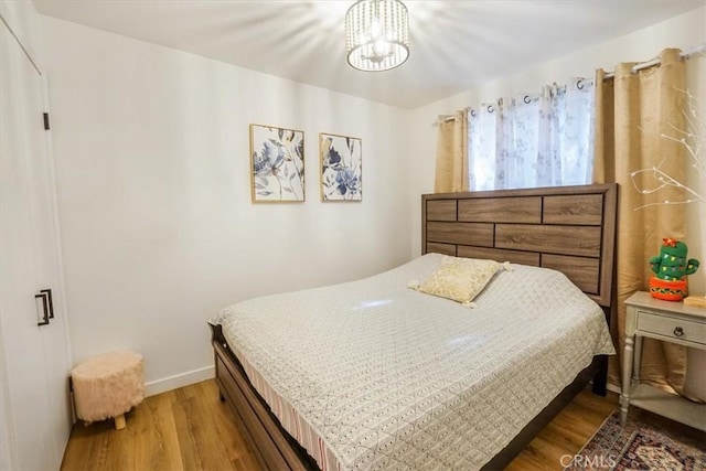 bedroom with a notable chandelier and hardwood / wood-style flooring