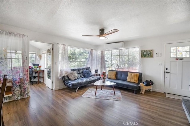 living room with a textured ceiling, ceiling fan, dark hardwood / wood-style floors, and a wall mounted air conditioner