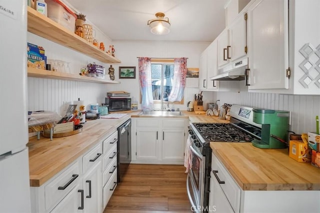 kitchen with white cabinets, sink, hardwood / wood-style flooring, appliances with stainless steel finishes, and butcher block counters