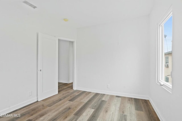 spare room featuring plenty of natural light and light hardwood / wood-style flooring