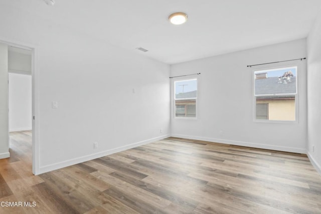 unfurnished room with light wood-type flooring and plenty of natural light