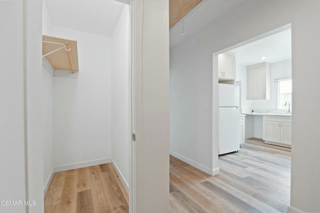 hallway featuring light hardwood / wood-style flooring and sink