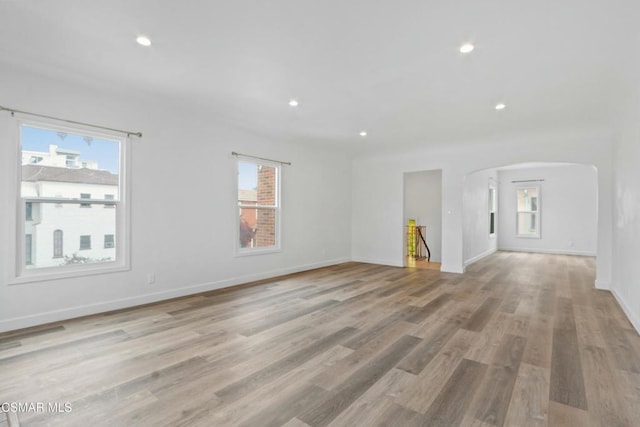 unfurnished living room featuring plenty of natural light and light wood-type flooring