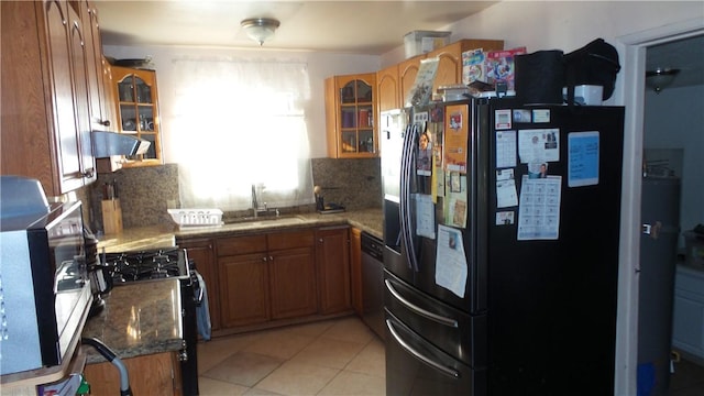 kitchen with black fridge with ice dispenser, exhaust hood, tasteful backsplash, and range with gas stovetop