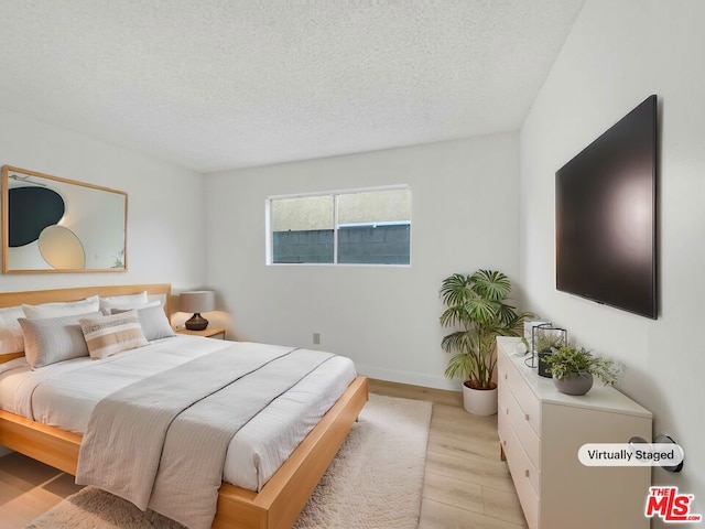 bedroom featuring a textured ceiling and light wood-type flooring