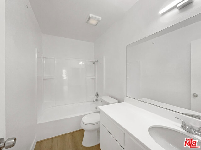 full bathroom with hardwood / wood-style flooring, vanity, toilet, and washtub / shower combination