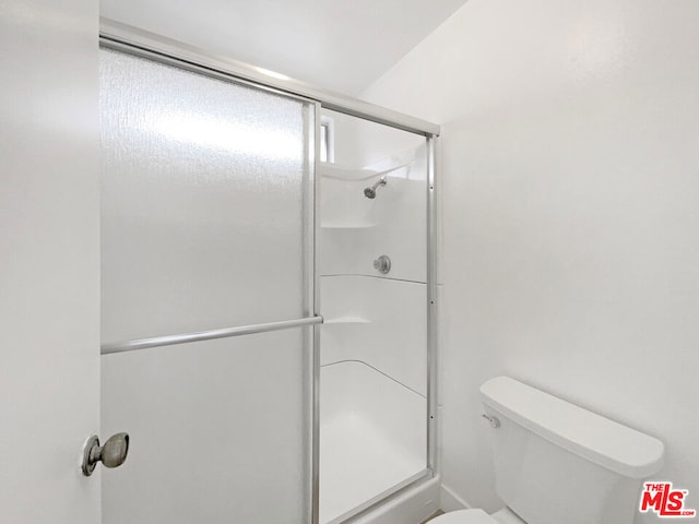 bathroom featuring toilet and an enclosed shower