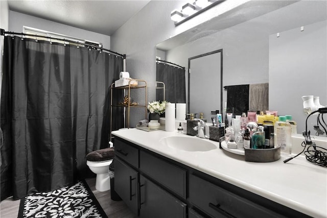 bathroom with hardwood / wood-style flooring, vanity, and toilet